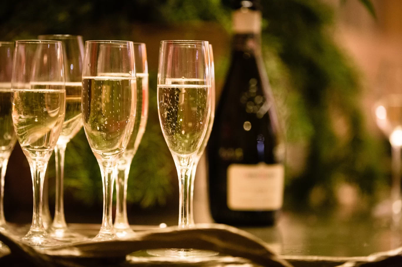 filled set of glasses with a bottle of wine in the background